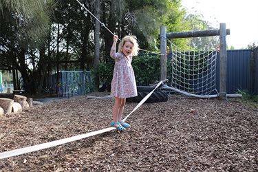 Child on a balancing rope at Sandhills Early Childhood Centre