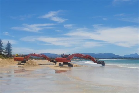 Machinery undertaking dune restoration beach scraping works on shoreline of Clarkes Beach Byron Bay