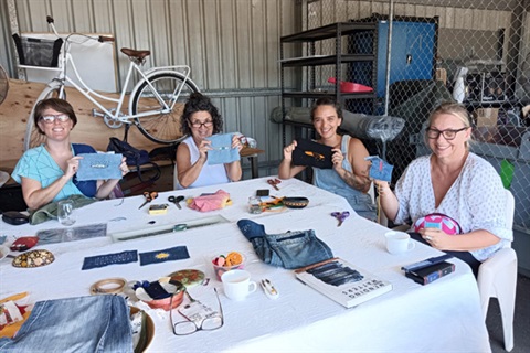 People sat round a table working with textiles