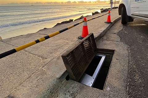 open drain in car park with ocean in the background
