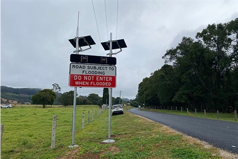 sign with solar panels warning drivers that when lights are flashing do not go further on the flooded road 