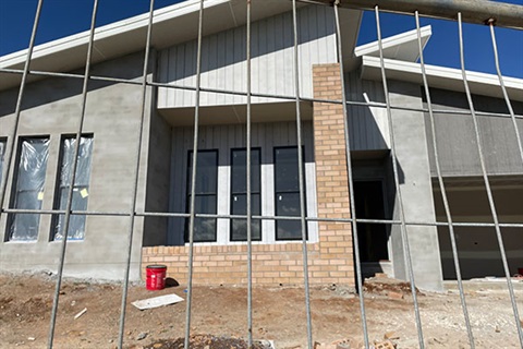 exterior of front of house under construction with fence in foreground