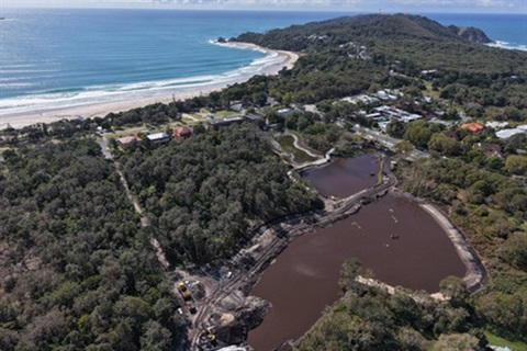 aerial of two large ponds with ocean in background