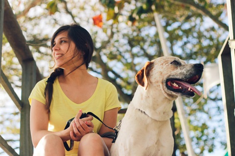 Photo by Cassiano Psomas on Unsplash Happy woman with dog on leash.